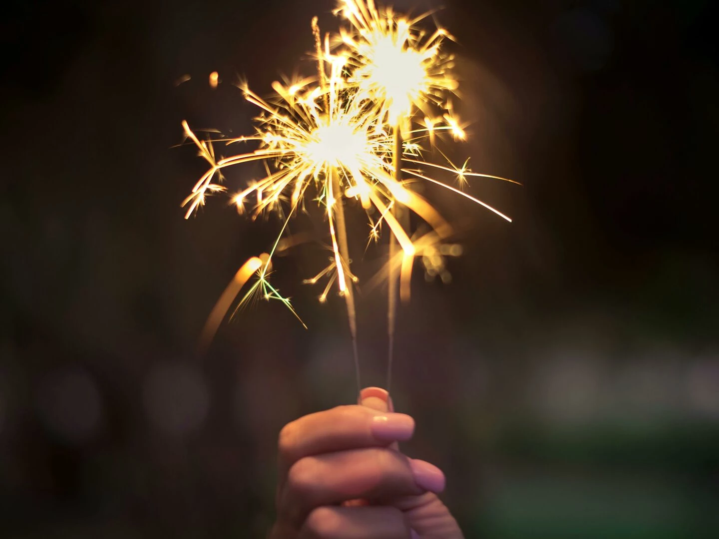 a hand holding sparklers glowing brightly in a dark night capturing the essence of celebration