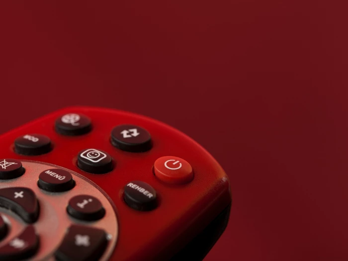 a red remote control on red surface