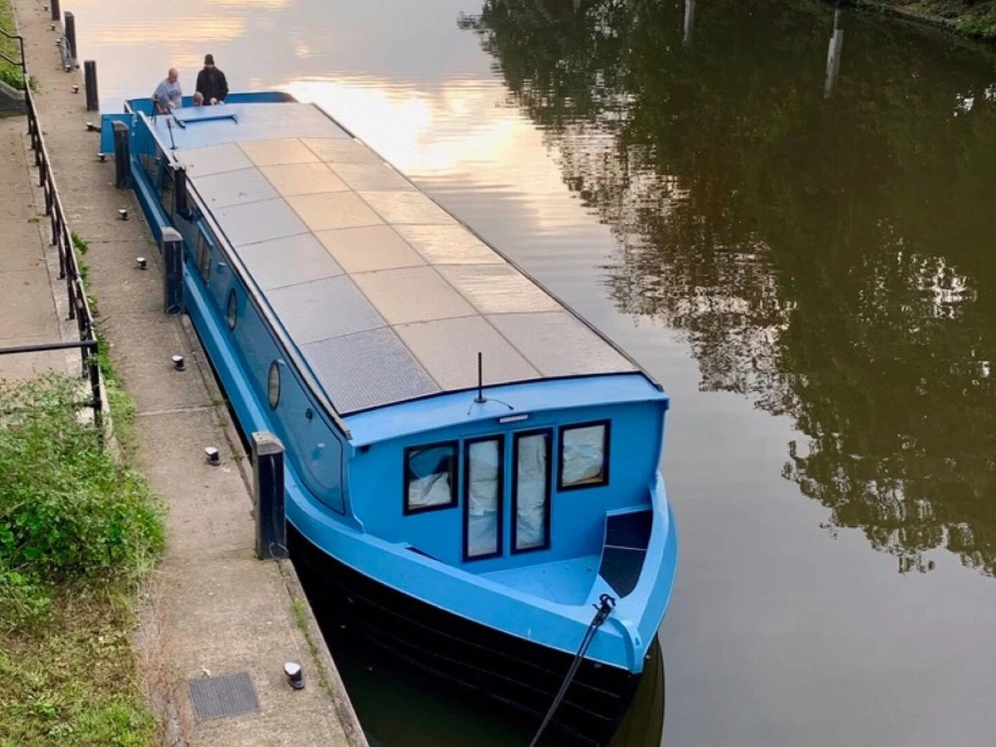 blue solarpowered electric boat moored up to the shore