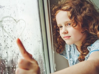 Child at window in rain