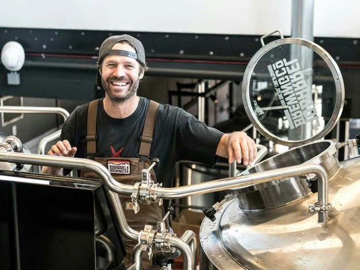 Happily Smiling Man Standing Near Gray Bars