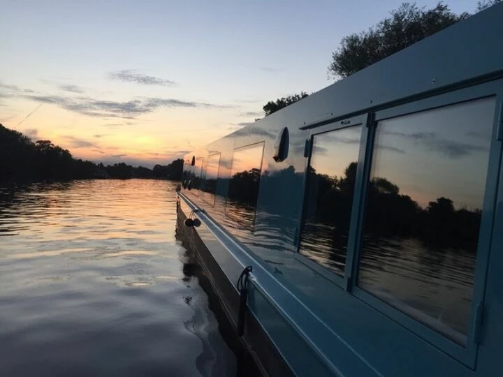 Eco boat sailing into the sunset on a canal waterway