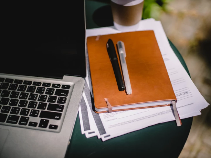 Planner and pens on table with laptop