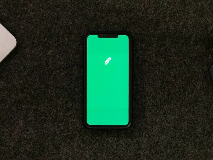 Smartphone displaying trading app on a desk for stock finance concepts.