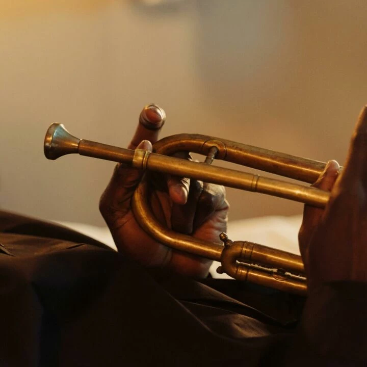 Artistic close-up of hands holding a brass trumpet, showcasing musical craftsmanship.