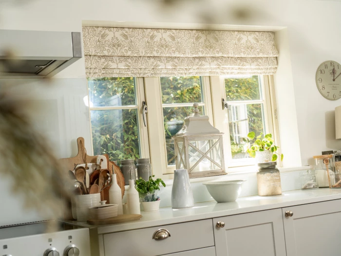Patterned roman blinds in cream and white kitchen