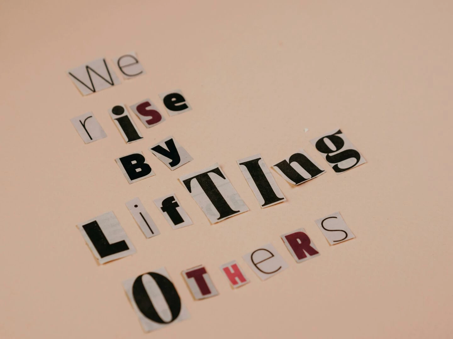 cutout letters forming an inspirational quote on a beige background encouraging positivity