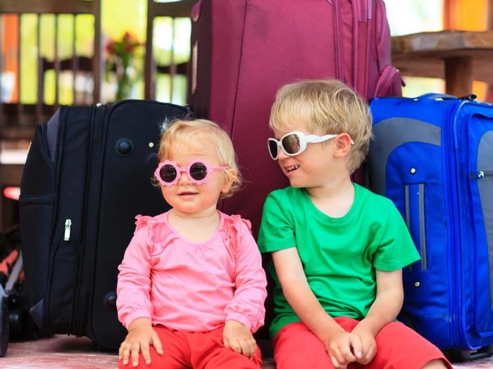 kids-sitting-on-suitcases-ready-to-travel
