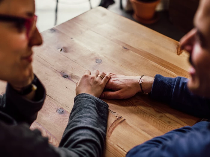man and woman sitting together in front of table