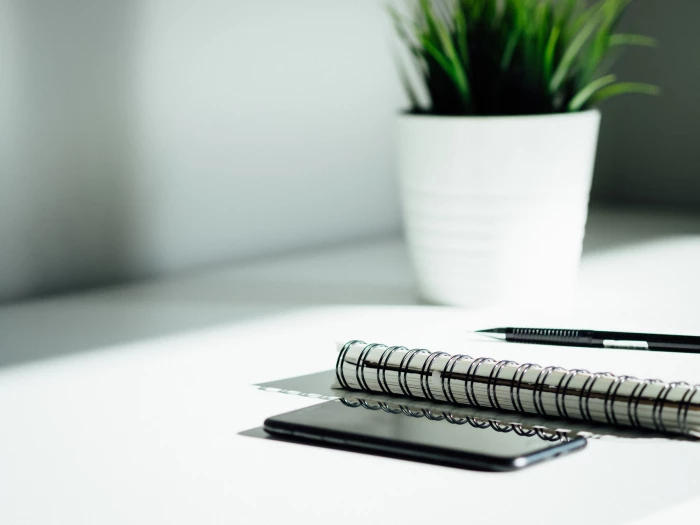 pen notebook and phone on a desk