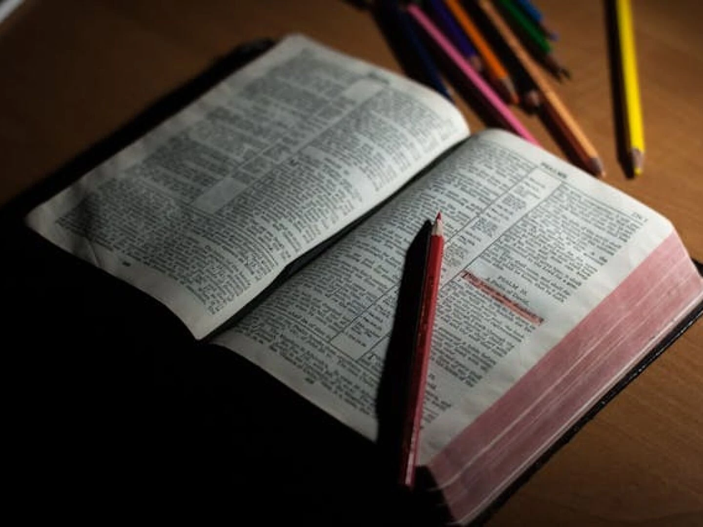 pink pencil on open bible page