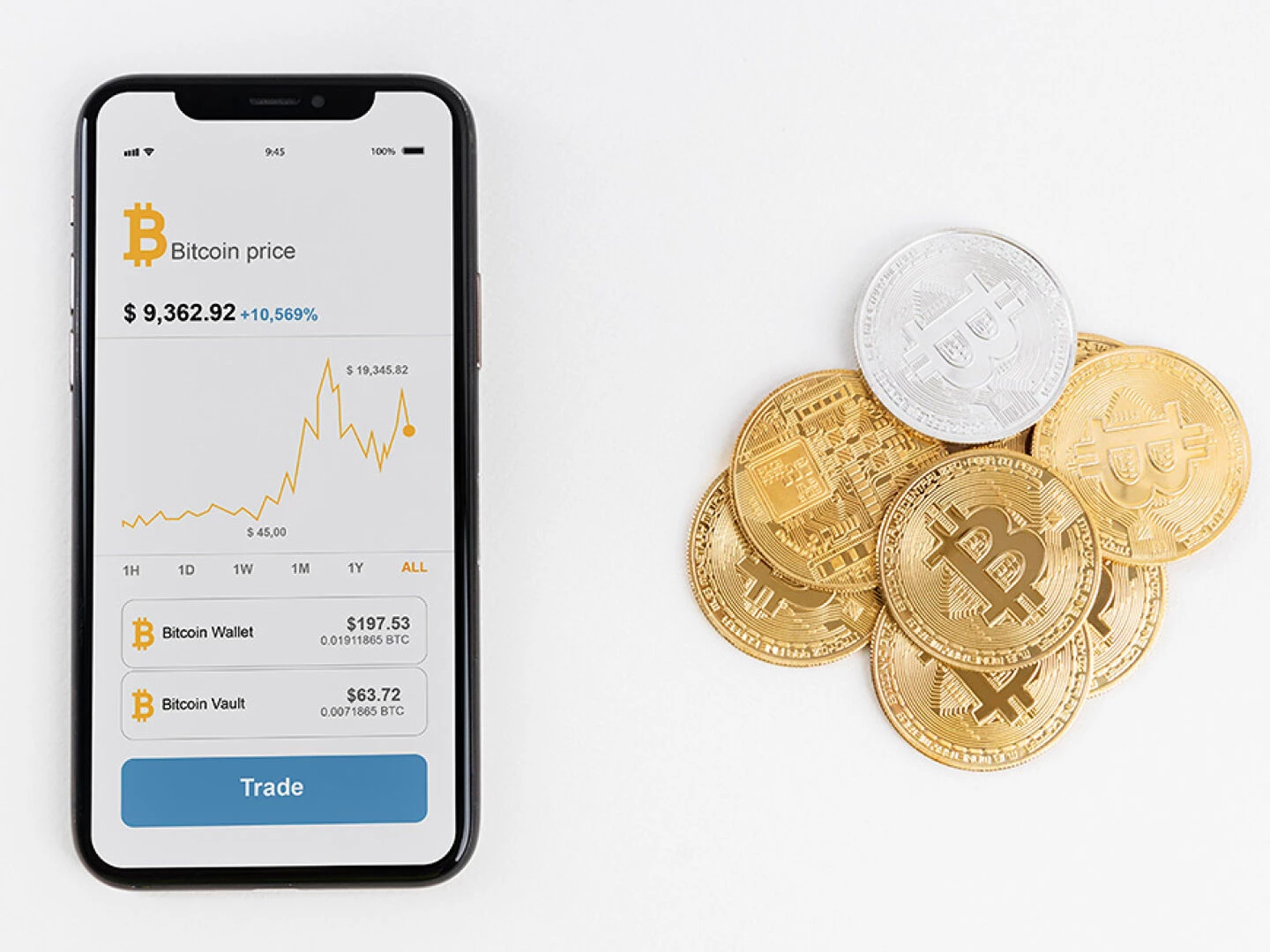 smartphone displaying live bitcoin price next to gold and silver cryptocurrency coins on a white background