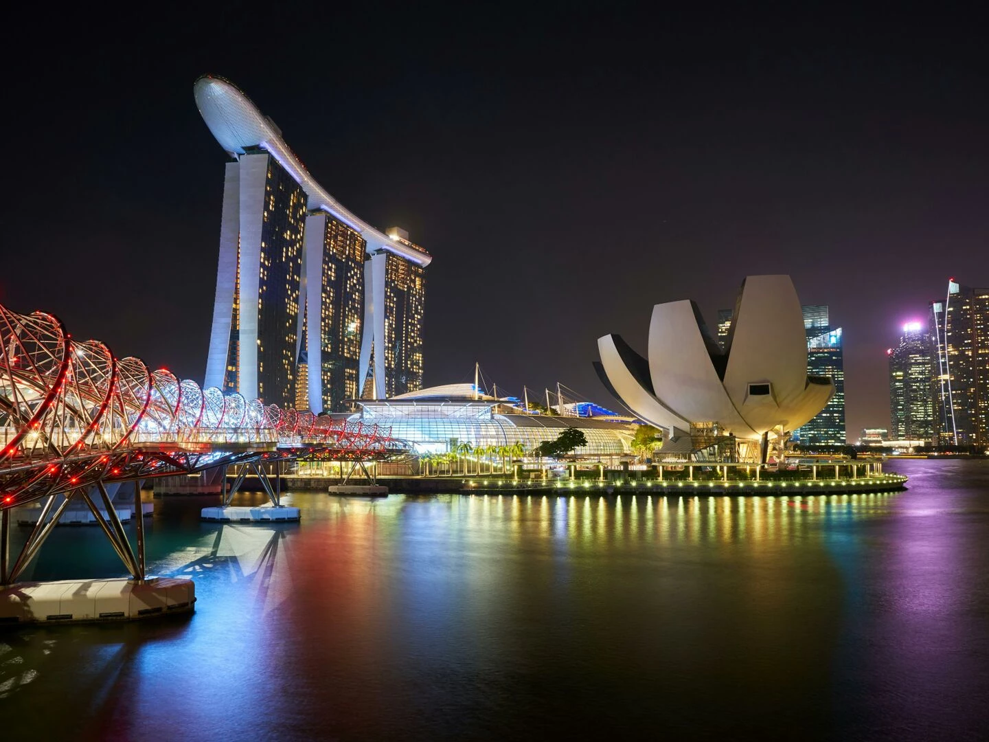stunning night view of marina bay sands and helix bridge illuminated over water in singapore