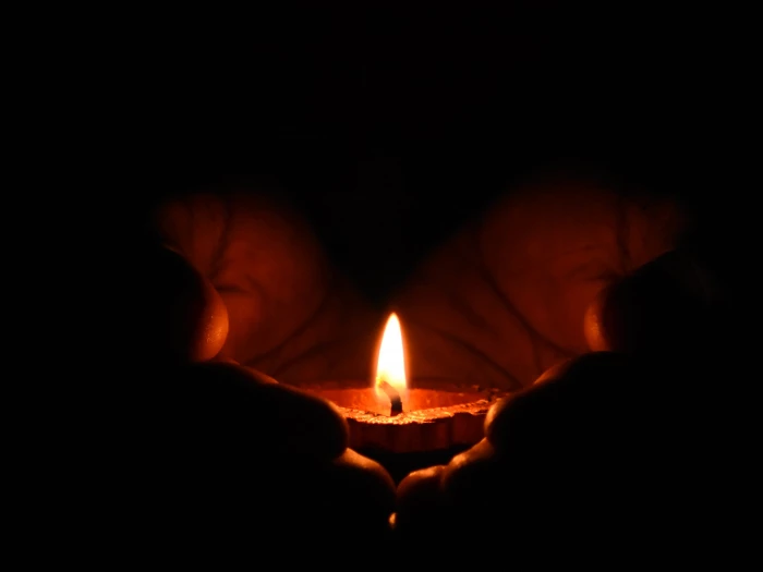 tealight candle on human palms