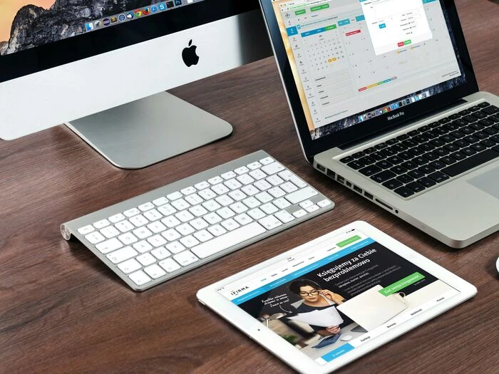 turned on imac beside macbook on table