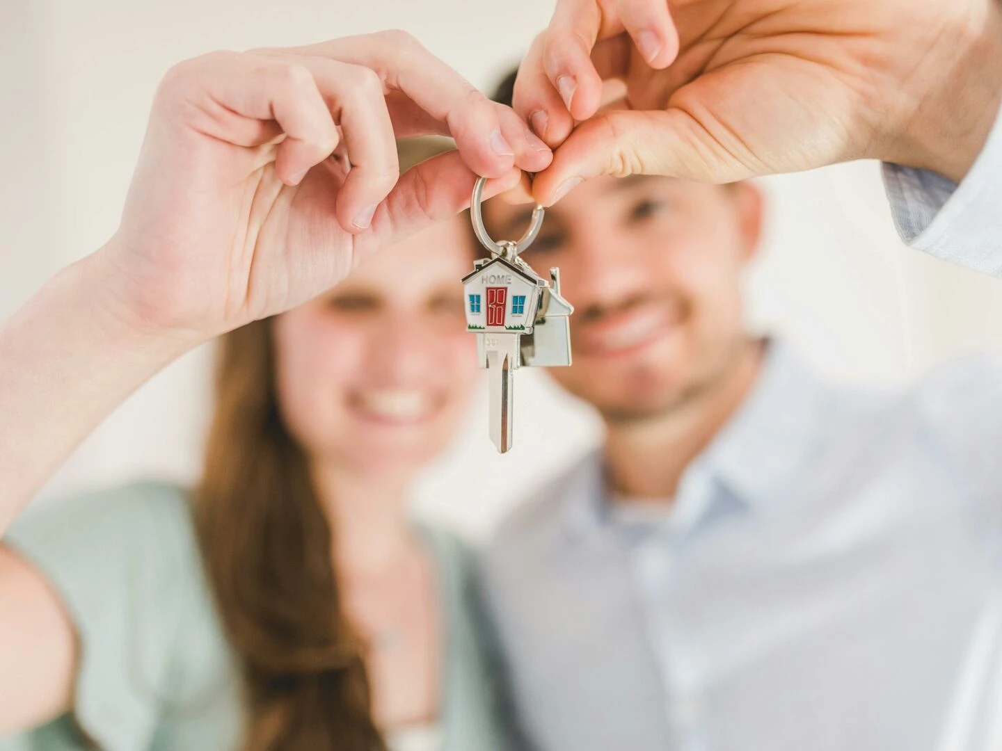 young couple holding keys to their new home symbolizing a fresh start and investment in real estate